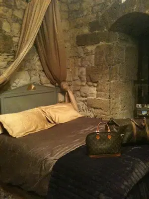 a bedroom with a bed with a stone wall at Château de Vedène in Vedène