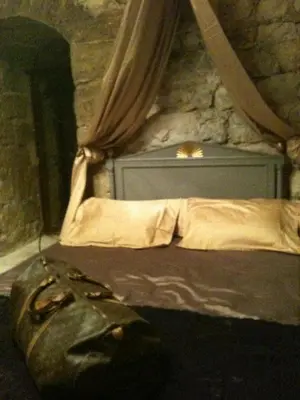 a bedroom with a bed with a stone wall at Château de Vedène in Vedène
