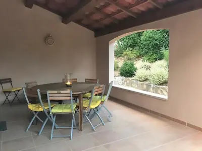 a dining room with a table and chairs and a window at Villa in Saumane near Golf Course and Pool in Saumane-de-Vaucluse