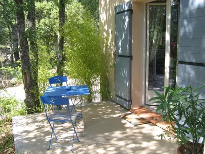 a blue table and chairs on the porch of a house at Les Restanques in Goult