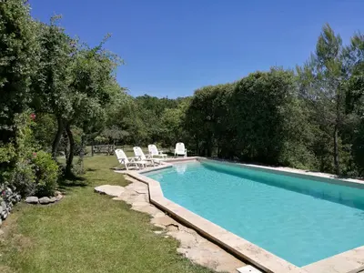 a swimming pool with white chairs at Les Restanques in Goult
