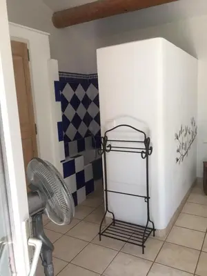 a bathroom with a fan and a wall at Les Restanques in Goult
