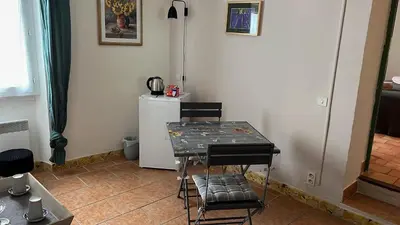 a kitchen with a table and chairs and a refrigerator at Domaine La Condamine CRILLON LE BRAVE in Crillon-le-Brave