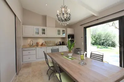 a kitchen with a wooden table with chairs and a chandelier at Mas De Gordes in Gordes