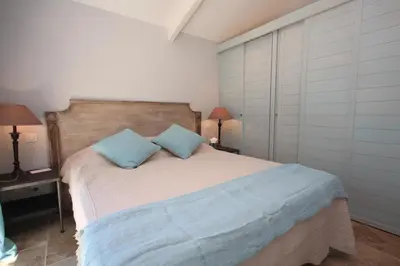 a bedroom with a bed with two blue pillows at Mas De Gordes in Gordes