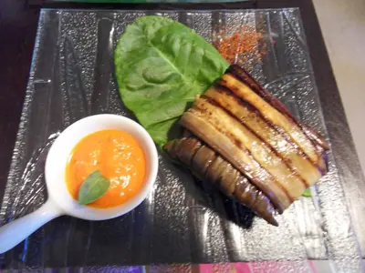 a plate with a sandwich and a cup of sauce at Le Jardin d'Ivana in Oppède
