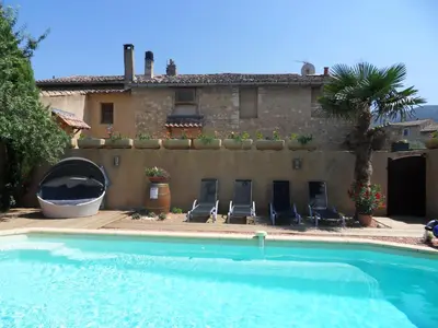 a villa with a swimming pool in front of a house at Le Jardin d'Ivana in Oppède