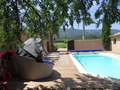 a swimming pool with lounge chairs next to a house at Le Jardin d'Ivana in Oppède