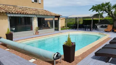 a swimming pool with a pipe in front of a house at Le Jardin d'Ivana in Oppède