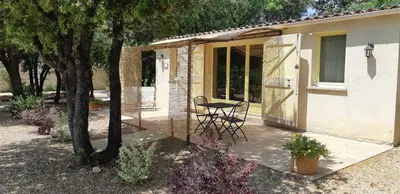 a patio of a house with a table and chairs at La Pitchounette Mas Val-Chênaie Gordes in Gordes