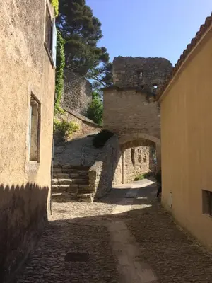 an alley with an archway in an old building at Rose in Bonnieux