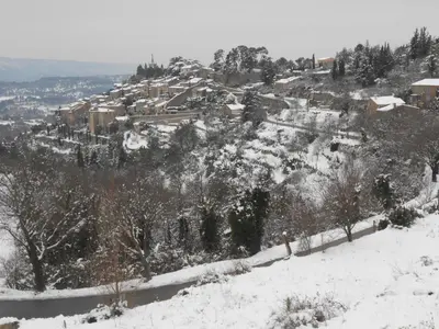 a snow covered hill with a town on it at Rose in Bonnieux