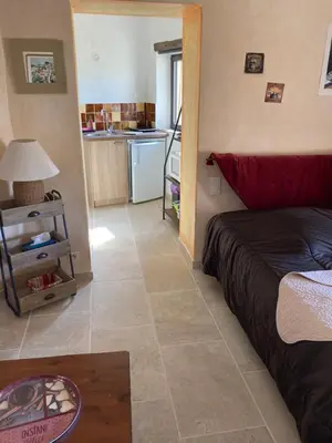 a living room with a bed and a kitchen at Rose in Bonnieux