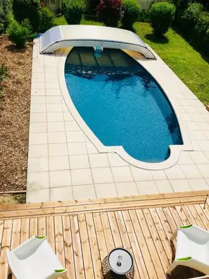 a swimming pool in a backyard with two chairs at Villa in Provence with private pool in LʼIsle-sur-la-Sorgue