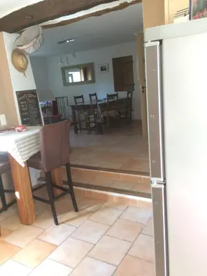 a kitchen and dining room with a refrigerator and a table at L'Oustaou de Rose in Bonnieux