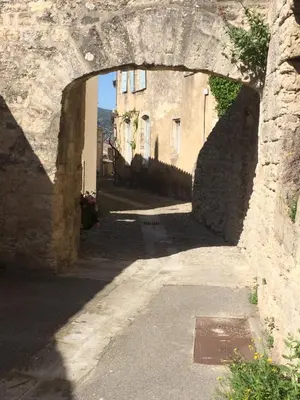an alley with an archway in a stone building at L'Oustaou de Rose in Bonnieux