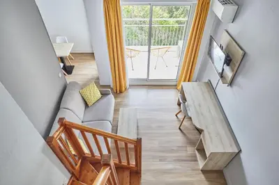 a living room with a couch and a table at Appart'hôtel Odalys City - Aix en Provence Ouest in Aix-en-Provence
