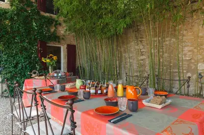 a table with orange plates and utensils on it at La Louvière des Bruyères in Robion en Luberon