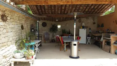 a patio with a table and chairs and a kitchen at Coin Secret in Murs