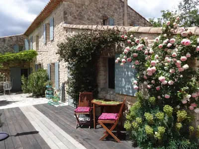 a patio with a table and chairs and a rose bush at Coin Secret in Murs