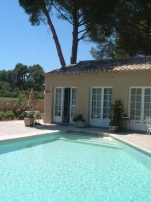 a swimming pool in front of a house at Gites Climatisés Piscine Chauffée La Balancelle in Saint-Rémy-de-Provence