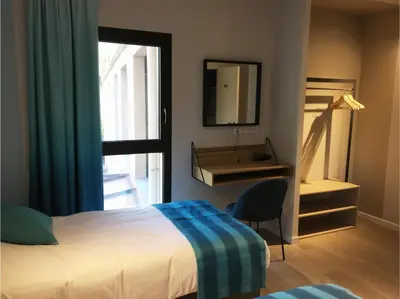 a bedroom with a bed and a desk and a mirror at Hotel Cantosorgue in LʼIsle-sur-la-Sorgue