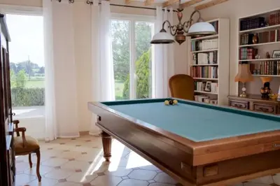 a pool table in a living room with a book shelf at Les murmures du Temps Villa 3 Chambres avec Piscine in Carpentras