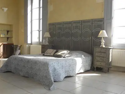 a bedroom with a bed with a book on it at Le Posterlon in Caumont-sur-Durance