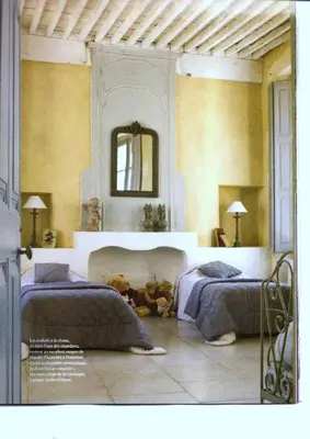 a bedroom with two beds and a mirror on the wall at Le Posterlon in Caumont-sur-Durance