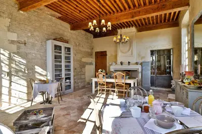 a kitchen and dining room with a table and chairs at Le Posterlon in Caumont-sur-Durance