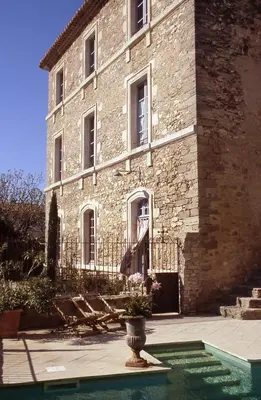 a large brick building with a vase in front of it at Le Posterlon in Caumont-sur-Durance