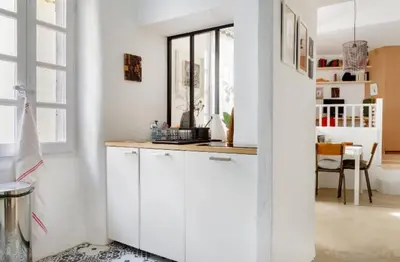 a kitchen with white cabinets and a window at Nuits étoilées Lourmarin in Lourmarin
