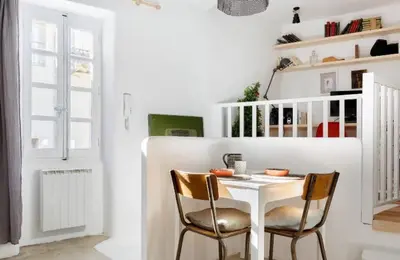 a white dining room with a table and two chairs at Nuits étoilées Lourmarin in Lourmarin