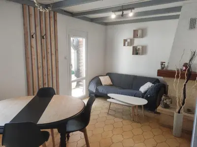 a living room with a blue couch and a table at Maisonnette in Carpentras