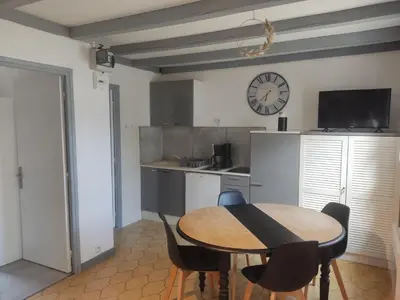 a kitchen with a table and chairs and a clock at Maisonnette in Carpentras