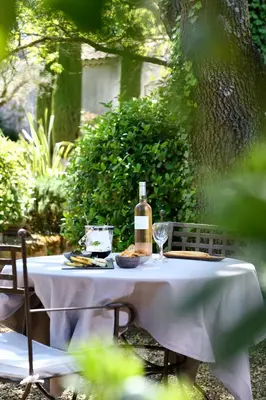 a table with a bottle of wine sitting on it at Les Mazets de Marie de Jules in Eyragues