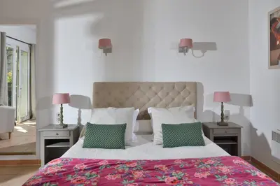 a bedroom with a large bed with two tables and two lamps at Les Mazets de Marie de Jules in Eyragues