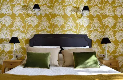 a bedroom with a bed with a floral wallpaper at Les Mazets de Marie de Jules in Eyragues