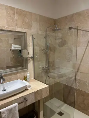 a bathroom with a glass shower and a sink at Le Mas Angelussi - Le Clos du Soleil in Salon-de-Provence