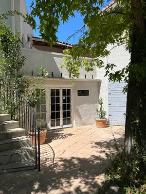 a front porch of a white house with potted plants at Le Mas Angelussi - Le Clos du Soleil in Salon-de-Provence