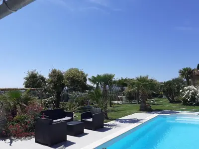 a swimming pool with two lounge chairs next to a resort at La Thomalie in Crillon-le-Brave