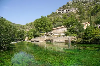 a river in front of a mountain with a building at BlueBird in Cavaillon