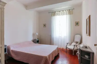 a bedroom with a bed and a chair and a window at Villa confortable à Caromb avec piscine privée in Caromb