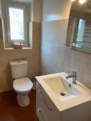 a bathroom with a toilet and a sink and a window at Villa confortable à Caromb avec piscine privée in Caromb