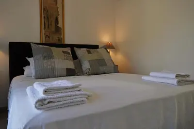 a bedroom with a bed with towels on it at Le Chat Sur Le Toit in Lourmarin