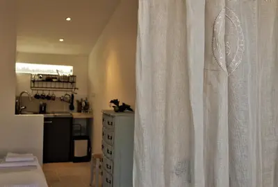 a white curtain in a room with a kitchen at Le Chat Sur Le Toit in Lourmarin