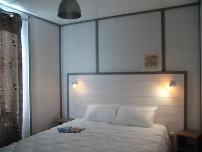 a bedroom with a large white bed with lights on it at La Colline des Ocres Village de vacances 3 étoiles in Apt