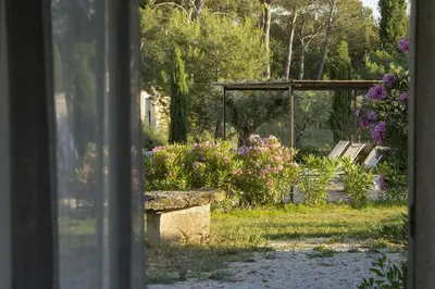 a stone bench sitting in a park with flowers at Mas Clair de Lune in Saint-Rémy-de-Provence