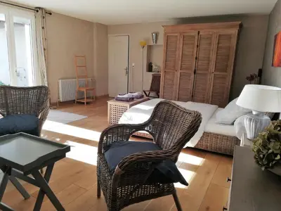 a living room with wicker chairs and a bed at La Goutadou in Cabannes