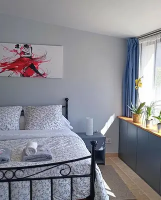 a bedroom with a bed and a painting on the wall at La Goutadou in Cabannes